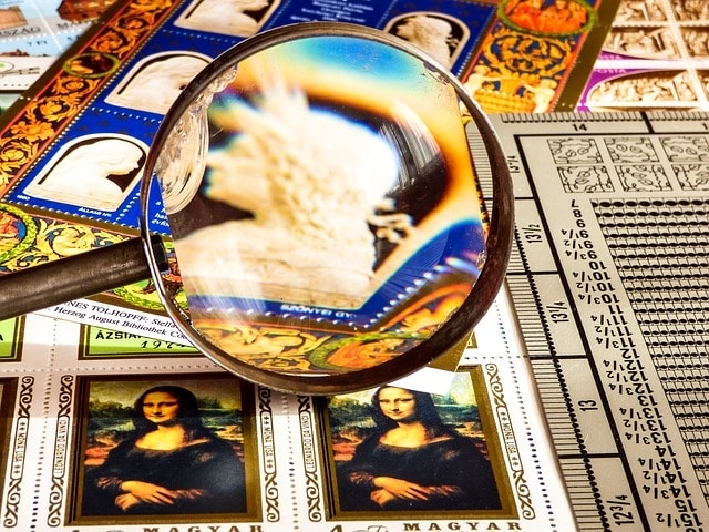 A magnifying glass through which stamp artwork can be seen