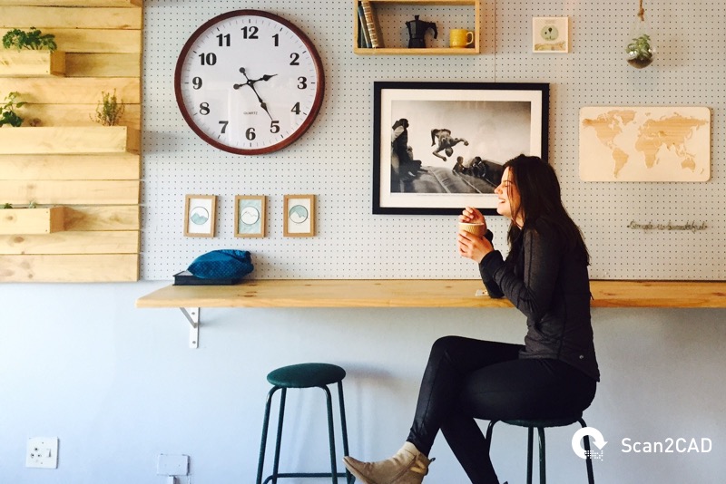 Woman seated at bench drinking coffee
